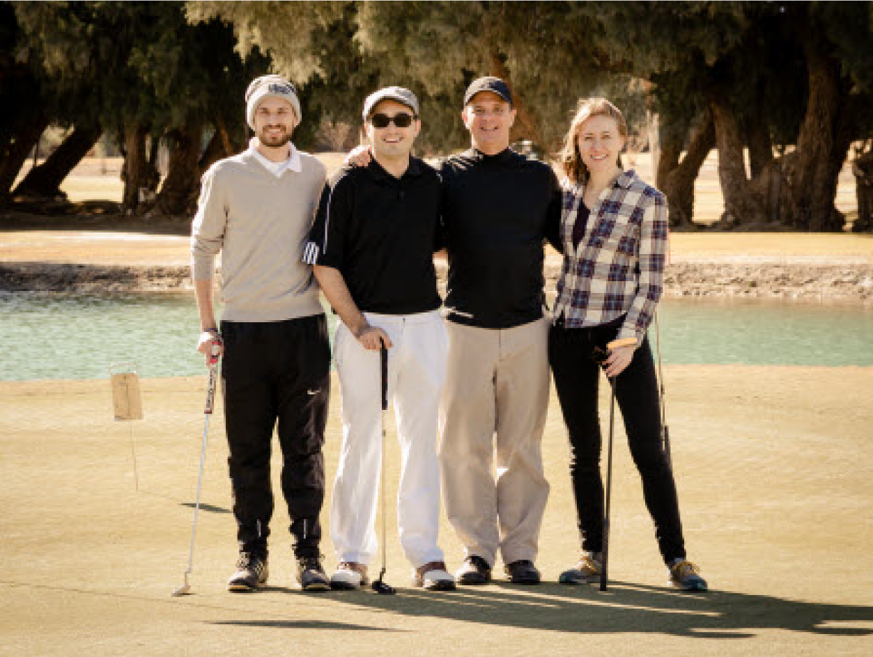 Four people standing together with the golf stick in their hands